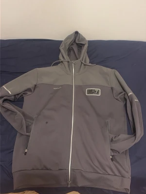 Ea7 kofta  - Säljer den här snygga koftan för bara 720 kronor den är ganska ny eftersom den är knappt använd har bara suttit där nypris 1900 kronor från jd sports pris kan gärna diskuteras.