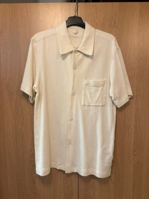 Arket skjorta - Kortärmad skjorta. Skjortan har en bröstficka och knäppning framtill. Perfekt för en avslappnad men snygg look. 