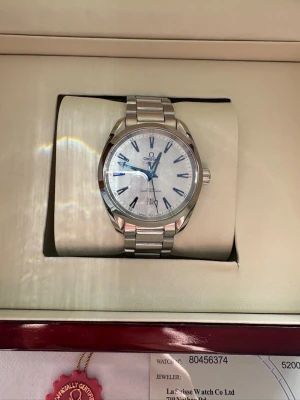 Omega Seamaster silver herrklocka - Snygg Omega Seamaster herrklocka med silverfärgat armband i metall och vit urtavla. Klockan har klassisk rund form och levereras i originalbox med certifikat och tillbehör. Perfekt för dig som gillar exklusiva accessoarer. Det är en aqua terra bejing os 2022 edition. Vänligen hör av er för fler bilder då plick drar ner på kvaliten