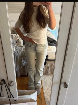 Ljusblå raka jeans - Säljer ett par ljusblå jeans med rak passform och klassisk femficksdesign. Jeansen har normal midja och är tillverkade i denim. Perfekta för en avslappnad och trendig look.