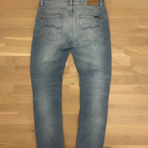 Lean Dean nudie jeans  - Säljer ett par galet schysta jeans från nudie! Dem har sjukt snygga lagningar från nudie själv och är i top skick. Modellen är leans dean vilket är en slim fit modell. Midja 42cm längd 102cm Benöppning nere 17cm 