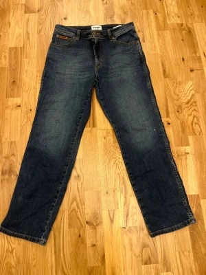 Ett par blåa wrangler jeans  - Blåa wrangler jeans i bra skick.