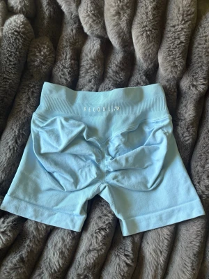Ljusblå  gym shorts från Relode - Säljer ett par ljusblå shorts från Relode. Shortsen har en tight passform och scrunch-detalj bak för extra shaping. dom sitter precis som dfyne enligt min åsikt. 