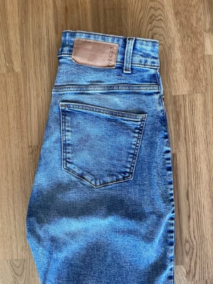 Blå jeans från Pieces, XS - Snygga blå jeans från Pieces i klassisk femficksmodell. Jeansen har en ljus tvätt och raka ben, samt detaljerade sömmar och bälteshällor. Perfekta för en avslappnad och trendig look.