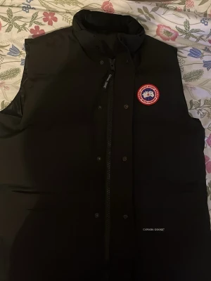Svart dunväst - Snygg svart dunväst med klassisk logga på bröstet. Den har ett pyttelitet hål i kragen som knappt märks men bra o veta. XXL sitter XL