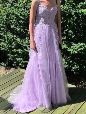 Lila långklänning med spetsdetaljer - Superfin lila balklänning med blommiga spetsdetaljer och v-ringad urringning. Klänningen har tunna axelband och ett lager av tyll som ger en drömmig känsla. Perfekt för bal eller student. Storlek 34