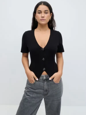 Svart v-ringad topp med knappar - Stilren svart topp från Weekday med v-ringning och korta ärmar. Toppen har tre dekorativa knappar framtill och en figurnära passform som ger en snygg siluett. Perfekt att matcha med jeans eller kjol för en trendig look.