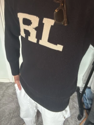 Ralph Lauren - Säljer denna snygga stickade tröja från Polo Ralph Lauren då den tyvärr var för liten för mig. Endast testad, alltså i helt nytt skick utan några defekter. Storlek small men kan absolut passa dig med storlek M också  Svart modell med klassisk "RL"-logga framtill i vitt, stilren och lätt att matcha. En av Ralph Lauren's mest rare ”knitwear” tröjmodeller. Perfekt till både vardag och finare outfits! Vid frågor eller funderingar är det bara att höra av sig😌