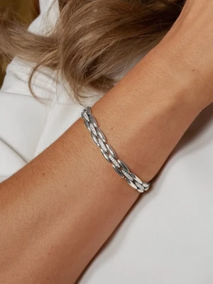 Mockberg Illume Bracelet - Snyggt armband i silverfärg med flätad design. Armbandet har en elegant och stilren look med detaljerade länkar som ger en modern känsla. Perfekt för dig som gillar minimalistiska accessoarer med en twist. Låset är diskret och smidigt.