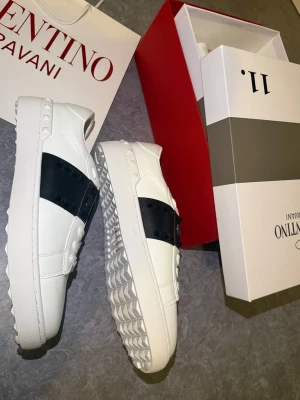 😎 Valentino Garavani 41 öppen skor vit stockholmsstil grisch nya rockstud Sneaker shoe open - Hej!!  Säljer dessa fina öppnaskor med nitar. I svart färg och vit Valentino Open modell. Jättefin om man stolar med fina jeans 👖😎 Skriv vid frågor eller funderingar. Storleken är 41. Passar dig med 40-41. Kan skicka omgående. Först till kvarn! MVH 🌞‼️