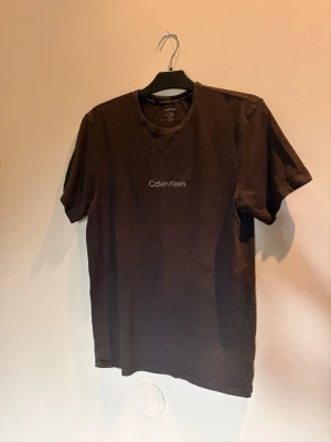 Svart Calvin Klein t-shirt - Snygg svart  t-shirt från Calvin Klein med diskret logga broderad på bröstet. Klassisk rund halsringning och korta ärmar. Tillverkad i mjuk bomull som känns skön mot huden. Perfekt till jeans eller shorts för en clean look.