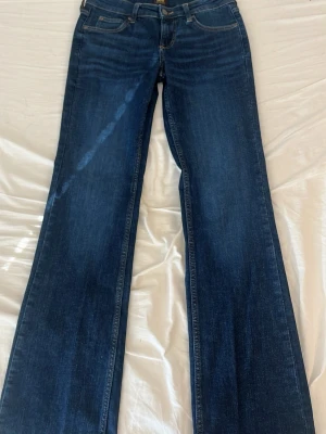 Mörkblå bootcut jeans från Lee - Snygga mörkblå low waist bootcut jeans från Lee med klassiska fem fickor och kontrastsömmar. 