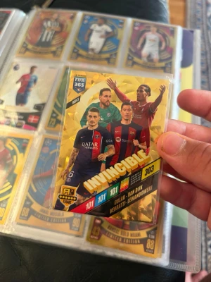 FIFA 365 Invincible samlarkort 2024 - Unikt FIFA 365 Adrenalyn XL Invincible samlarkort från 2024 med spelare som Oblak, Van Dijk, Verratti och Lewandowski. Kortet har guld och färgglad design, nummer 303, och är perfekt för samlare av fotbollskort.