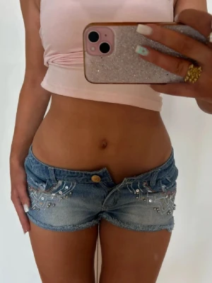 Lågmidjade vintage jeansshorts med pärlor  - Såå fina blå  lågmidjade vintage jeansshorts med broderi, paljetter o pärlor! midjemått rakt över: 39. Jag är 168 och det är mina bilder, köp via köp nu direkt eller Swish, kvar tills markerad som såld 💖 