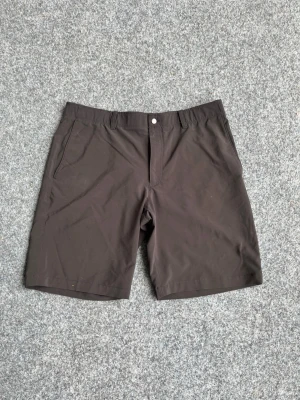 Bruna golfshorts från Callaway - Snygga bruna golfshorts från Callaway med klassisk passform. Shortsen har två sidofickor fram och två bakfickor samt bälteshällor. Tillverkade i ett lätt och stretchigt material som passar perfekt för sportiga aktiviteter under sommaren.