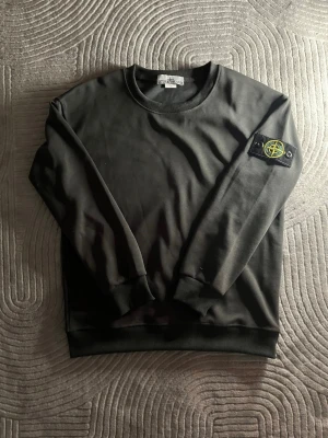Stone Island Tröja - Hej hej, säljer en grå stone Island tröja i ny skick. Den säljs på grund av att den var liten. Har även en lika dan i grön på min profil 😁Den ända lilla defekten är att lappen är lös men den sitter fortfarande på på en av sidorna och det syns ju inte när man har den på sig såklart, priset har därav dragits av lite på denna tröja! Hör av er vid frågor 🤟