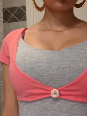 Crop top knapp botton rosa - Trendig söt rosa crop top som knäpps med en knapp. Passar S. Axelbredd: 36 cm men stretchigt tyg, längd: 28 cm. 