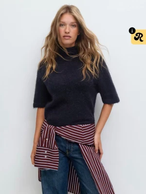 Mörkblå stickad tröja med krage - Mysig mörkblå stickad tröja med halvpolo och korta ärmar. Tröjan har en avslappnad passform och är tillverkad i ett mjukt, luddigt material som ger en trendig look. Perfekt att styla med jeans eller kjol för en cool vardagsoutfit.