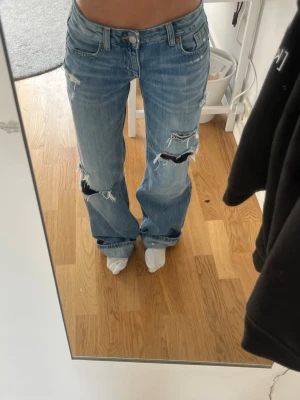 Baggy low jeans - Säljer dessa superfina och populära baggy jeans från Zara med slitningar eftersom det är för långa för mig. Det är i storlek 32 och i bra skick eftersom de endast är använda ett fåtal gånger. Bara att skriva vid frågor eller funderingar!!