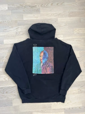 Van Gogh-hoodie - Reclaimed Vintage - svart, M - Mycket bra skick. Inga tecken på användning Hoodie från Reclaimed Vintage, storlek M, svart Huva med snörning, stor framficka. Litet tryck fram och stort tryck bak med “Van Gogh”-motiv Bröstvidd: 60 cm Längd: 70 cm Bomull, elastan. Inga defekter