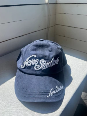 Acne Studios keps  - Snygg mörkblå keps från Acne Studios med broderad logga framtill. Justerbar rem baktill för perfekt passform. Hör gärna av er! 