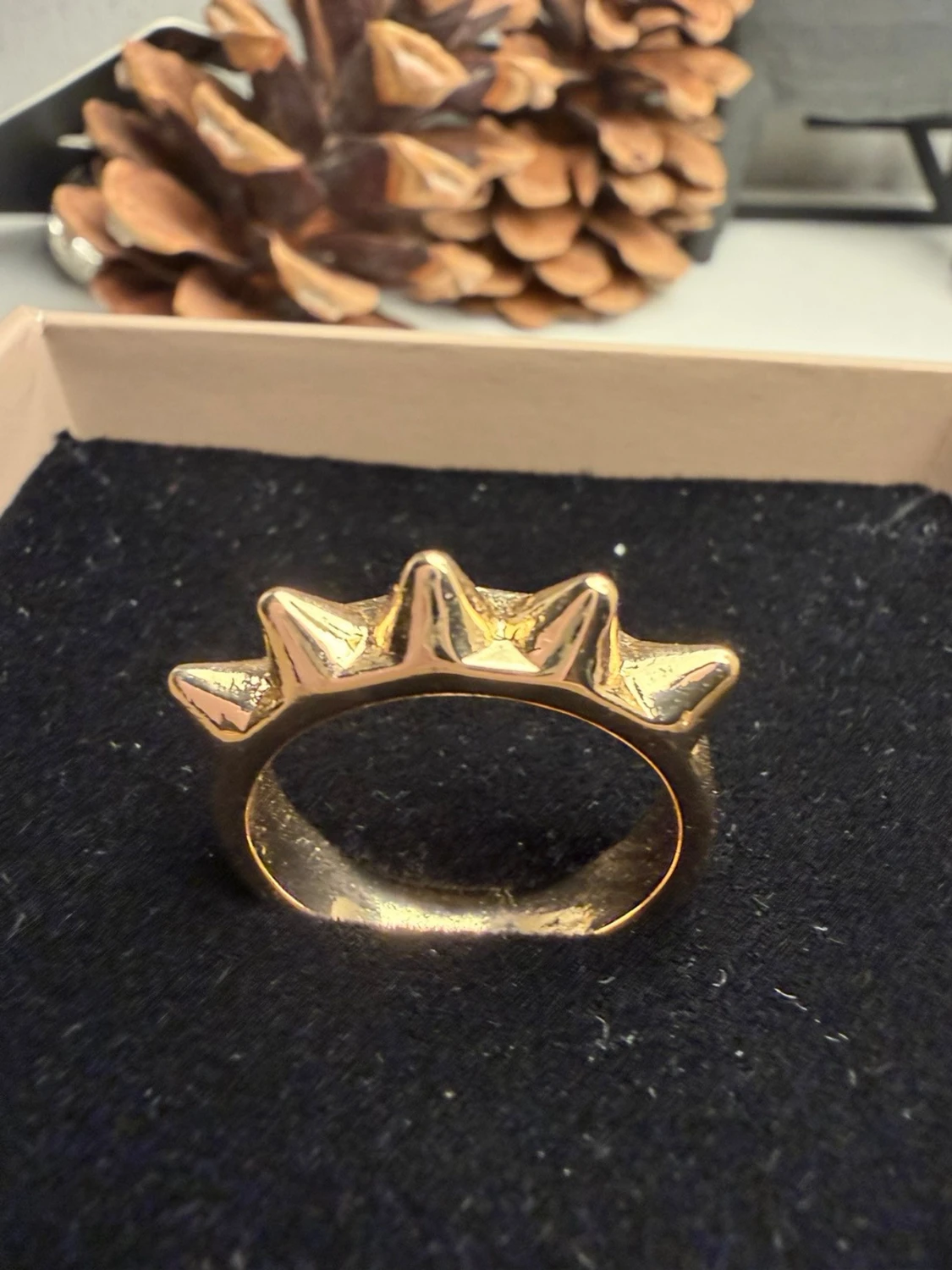 Guldig ring med pyramidformade detaljer