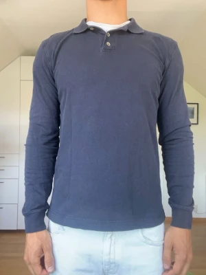 Mörkblå långärmad piké  - Mörkblå Långärmad piké från Hansen & Jacob tillverkad i 95% bomull och 5% elestan. Strl S. Inga defekter. Modellen är 178 cm och väger 77 kg. Hör gärna av dig vid frågor!