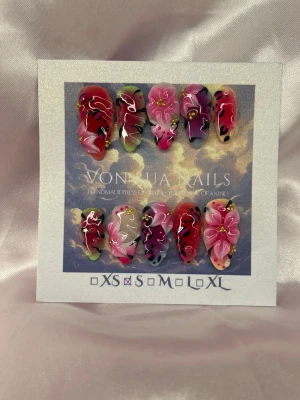 SafariLuxe (S);Medium Almond - Unika handgjorda press-on naglar med handgjorda blommor i rosa, rött  toner. Naglarna har detaljer i svart, vitt och guld samt små pärlor. Formen är medium långa almond och designen är livlig och konstnärlig. Perfekt för dig som vill sticka ut med färgstarka naglar.S: 15 mm, 11,5 mm, 12 mm, 11 mm, 9 mm 