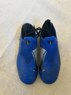 Nike fotbollsskor stl 36,5 - Nike fotbollsskor i storlek 36,5, har en blå utsida med silvriga och svarta detaljer. Har både smöre och strumpa. Det var svårt att få en bra bild på  storleken men står i skon. 