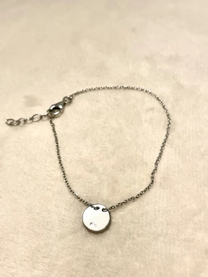 Armband med berlock - Ett stilrent armband med en rund berlock, stämplat 925 sterlingsilver 🤍armbandet är ca 8cm långt ❣️Billigare vid snabb affär - skicka ett prisförslag! 