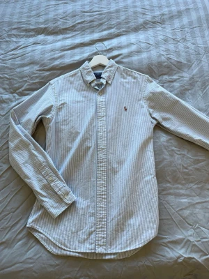 Ralph lauren skjorta - Vitblå randig Ralph lauren skjorta, har vuxit ur den så dags att tacka adjö… riktigt snygg och varsamt använd