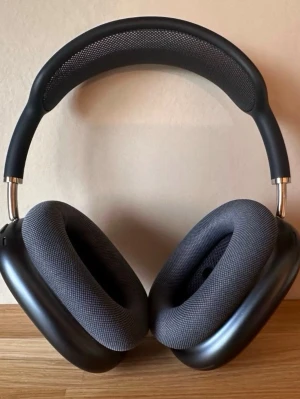 Apple AirPods Max svarta hörlurar - Snygga over-ear hörlurar från Apple, AirPods Max, i svart färg. De har en robust aluminiumram, mjuka öronkuddar i mesh-material och ett justerbart huvudband med mesh för extra komfort. Perfekt för dig som vill ha grymt ljud och stilren design.