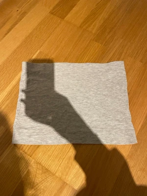 Grå basic kjol\tube top - En enkel och stilren grå kortkjol i mjukt bomullsmaterial med stretch. Kjolen har en rak passform och är perfekt för en avslappnad look. Inga synliga detaljer eller mönster, bara basic och clean. Går även att använda som tubetop. Skickar helst med PostNord😊