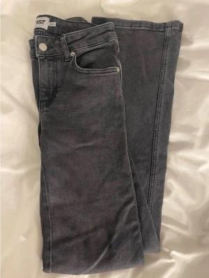 Svarta bootcut jeans från lager 157 - Säljer ett par svarta straight jeans från lager 157 med råa, fransiga benslut och klassiska fem fickor. Perfekta för en avslappnad och trendig look.