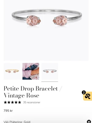 Petite Drop armband Vintage Rose - Jag har inte asken kvar. Ett stilrent armband i silverfärg med två droppformade rosa stenar i varje ände. Armbandet har en tunn, elegant design och de rosa stenarna ger en romantisk touch. Perfekt för att lyfta vilken outfit som helst.