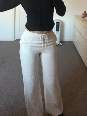 Vit/begiea linnebyxor  - Säljer ett par linnebyxor. Byxorna är tillverkade i ett mjukt, tunt material som känns skönt mot huden. Perfekta för sommaren!!