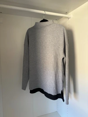Grå långärmad tröja  - Använd få tillfällen så i fint skick, har lite högre hals och slits i sidorna.