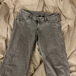 Gråa vida jeans från 7 For All Mankind - Säljer ett par gråa bootcut jeans. Jeansen har en snygg tvättad look och är tillverkade i mjukt denim-material. Perfekt för dig som gillar en avslappnad och trendig stil. Storlek 40 men skulle säga att den mer passar 38.