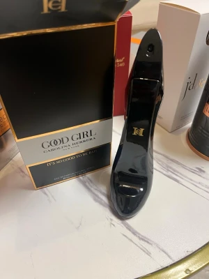 Good Girl parfym från Carolina Herrera 80ml - HELT FULL!!!!Good Girl från Carolina Herrera är en lyxig parfym i en elegant svart flaska formad som en högklackad sko med gulddetaljer. Flaskan är tillverkad av glas och har en modern, glamorös design som verkligen sticker ut på hyllan. Perfekt för dig som gillar exklusiva dofter 80ml.