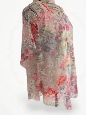 Blommig transparent blus i mesh - Säljer en luftig och transparent blus i mesh med blommigt mönster i rosa, lila, orange och grönt. Blusen har lös passform, korta ärmar och rund halsringning. Perfekt för dig som gillar färg och vill sticka ut lite extra.