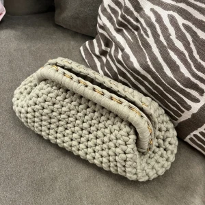 Handvirkad grön kuvertväska - Unik handvirkad kuvertväska i grönt tjockt garn med mjuk struktur. Väskan har en stadig ram upptill och detaljer i guld. Perfekt för dig som gillar personliga accessoarer. Kan användas som både necessär och clutch/kuvertväska. Så fin inför sommarens alla tillfällen☺️