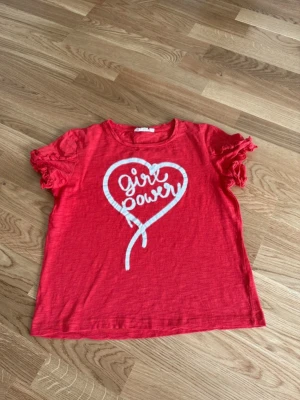 Topp volanger - Topp med volanger på ärmarna och tryck där det står girl power.  Från Kappahl i storlek 158/164. Nyskick.  