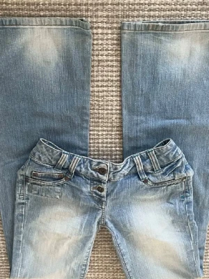 Lågmidjade ljusblåa jeans  - Perfekta lågmidjade unika jeansen, jätte bra skick! Mått kommer. Inte slitna vid bena eller något sånt. Vintage jeans. Står w32/l34 i jeansen, skulle säga 25/26. Finns massa mer lågmidjade jeans uppe, kika! 