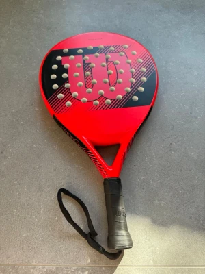 Wilson padelrack - Wilson Striker padelrack Kolla bild på mindre defekter, utöver det är det utmärkt skick på racket!  Nypris 800kr