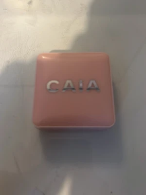 CAIA puder roge - Snyggt puder roge från CAIA i en persikofärgad nyans. Kommer i en söt, ljusrosa fyrkantig dosa med spegel i locket – perfekt att ha med i väskan. Ger ett fräscht glow och är lätt att applicera med fingrar eller borste. I färgen lemonade nånting det på baksidan har skrapats av så jag kan inte se!