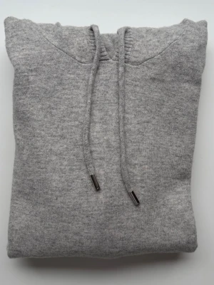 Grå hoodie i 100% ull – strl S - Säljer en grå hoodie i 100% ull, storlek S. Tunn, mjuk och skön, Endast använd en gång, mycket bra skick,Inget märke. Passar både till vardag och en stilren outfit.   