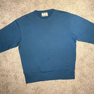 Acne studios crewneck - Säljer min teal blue acne crewneck tröja i storlek S. Den är bara använd några gånger och är därför i väldigt bra skick. Prislapp finns kvar (3:e bilden). Originalpris är 1700kr men är köpt för 1190kr hos acne archive, då det är en äldre kollektion.