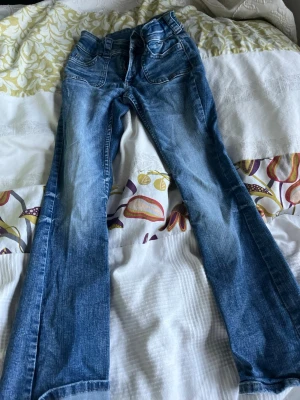 Blå bootcut jeans med fickdetaljer - Söta jeans för barn ca 10-13 år! Bra skick