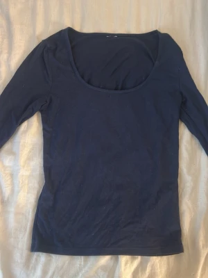 Mörk blå långärmad  - En urringad tröja från Gina, prislappen är dock bortklippt.