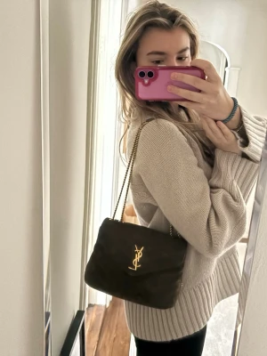 Saint Laurent axelväska i mocka - Säljer denna jättefina Saint Laurent loulou bag.   Väskan är i grön/brun mocka och fint använt skick. Lite skavd på baksidan, samt små små fläckar (syns knappt), så kolla bilderna. Mocka är ett känsligt material så därför blir det enkelt skador.   Perfekta väskan som man kan ha på axeln /crossover och som handväska.   Jag har själv köpt den begagnad och då var den äktahetsverifierad av sidan.   Hör av er vid frågor. Pris kan diskuteras♥️ 
